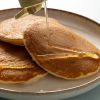 Biologische agavesiroop wordt over een stapel pannenkoeken geschonken