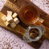 Rooibos Drakenvuur thee met theezeefje en nougat op houten plank