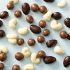 Biologische chocolade notenmix verspreid over een lichtblauwe achtergrond