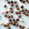 Biologische crunchy choco’s verspreid over een lichtblauwe achtergrond