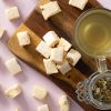Soft nougat vanille geserveerd op een houten plank met een kop thee