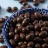 Close-up van biologische melkchocolade pinda's in een decoratief schaaltje.