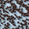 Biologische melkchocolade pinda's verspreid over een lichte achtergrond.