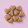 Chocolade hartjes karamel (9 stuks) op een lichtroze achtergrond