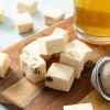 Zachte roomnougat met noten op een houten plank naast een glas thee