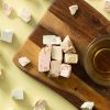 Haknougat met verschillende smaken geserveerd op een houten plank met thee