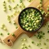 Wasabi erwten in zwart schaaltje op houten plank