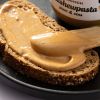 Close-up van romige cashewpasta op een snee meergranenbrood