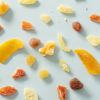 Losse stukjes Bermuda fruitmix verspreid over een lichtblauwe achtergrond