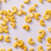 Spicy cashew bites verspreid over lichtpaarse achtergrond