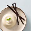Vanilledessert met drie vanillestokjes en een takje munt