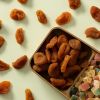 Zure abrikozen in een houten vakjesbak met gedroogd fruit