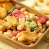 Close-up van rigato mix met gekleurde en krokante snacks in een houten schaaltje