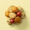 Kingbollen mix met verschillende krokante snacks en rode crackers op een lichtgele achtergrond