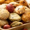 Close-up van kingbollen mix met verschillende krokante snacks en rode crackers in een houten schaaltje