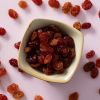 Rode crimson rozijnen in een vierkant schaaltje