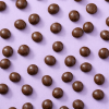 Melkchocolade kruidnoten biologisch verspreid op een paarse achtergrond