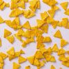 Mini tortilla chips los verspreid over een lichtpaarse achtergrond