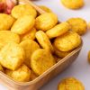 Close-up van baked round curry crackers in een houten schaaltje