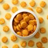Baked round chili crackers in een wit schaaltje met crackers eromheen