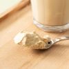 Close-up van erwten eiwitpoeder naast een eiwitshake