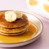 Stapel pannenkoeken met banaan en biologische ahornsiroop