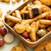 Close-up van rijstcrackers nori mix met verschillende krokante snacks in een houten schaaltje
