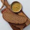 Roggebrood met kom soep op houten plank