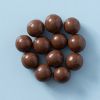 Chocolade macadamia noten op een lichtblauwe achtergrond