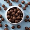 Schaaltje met melkchocolade macadamia noten van bovenaf gefotografeerd