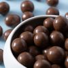Schaaltje met melkchocolade macadamia noten van bovenaf gefotografeerd