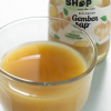 Close-up van een glas met biologisch gembersap en fles op de achtergrond