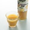 Glas biologisch gembersap met de fles op de achtergrond