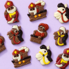 Assortiment chocolade Sinterklaasfiguurtjes verspreid op een lichtpaarse achtergrond