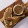 Brood met romige pecanpasta en een open pot op een houten plank