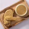 Brood met romige hazelnootpasta en een open pot op een houten plank