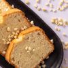 Close-up van plakjes cake met amandelstukjes wit ongebrand op een zwarte schaal