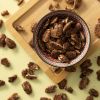 Pecannoten kaneel zeezout in een schaaltje op een houten plank