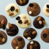 Gemengde Studentenflikken van melk, pure en witte chocolade met noten en rozijnen