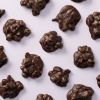 Pure chocolade pindarotsjes met pinda’s op paarse achtergrond