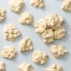 Witte chocolade pindarotsjes met pinda’s op lichtblauwe achtergrond