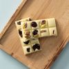 Witte chocolade Choc block met gedroogde bessen en pistachenoten op houten plank