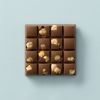 Melkchocolade choc block met stukjes hazelnoot op een lichtblauwe achtergrond