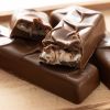 Melkchocolade choc bars coconut cream met zichtbare kokosvulling op houten plank