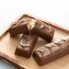 Chocolates For You choc bars Caramel kiss op een houten plank, waarvan één opengebroken met zichtbare karamenvulling