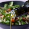 Chiazaadolie wordt over een salade geschonken