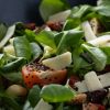 Close-up van een salade met veldsla, tomaat, kaas en chiazaadolie