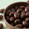 Een close up van de melkchocolade amandelen in een rond schaaltje