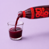 Granaatappelsap wordt vanuit de fles in een glas geschonken