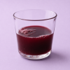 Glas gevuld met donkerrood granaatappelsap
